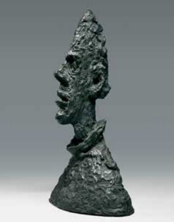A dark, abstract sculpture of a human face and neck in profile, with rough, textured surface.